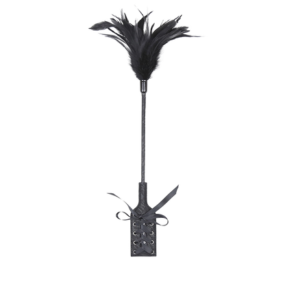 Black feather whip with an attached paddle with vintage design on a white background.